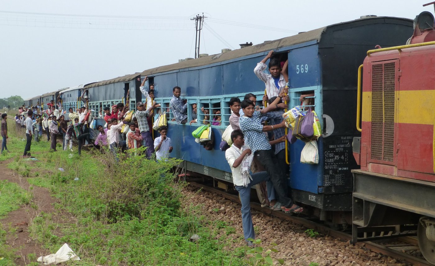 Crowds of people travelling on a overcrowded train