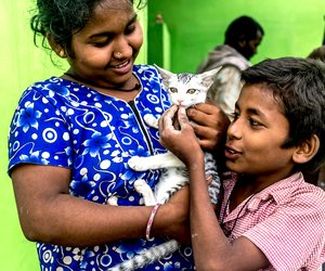 Kavita, 16, and her brother, Anil, around 12, find solace with Honey, their cat